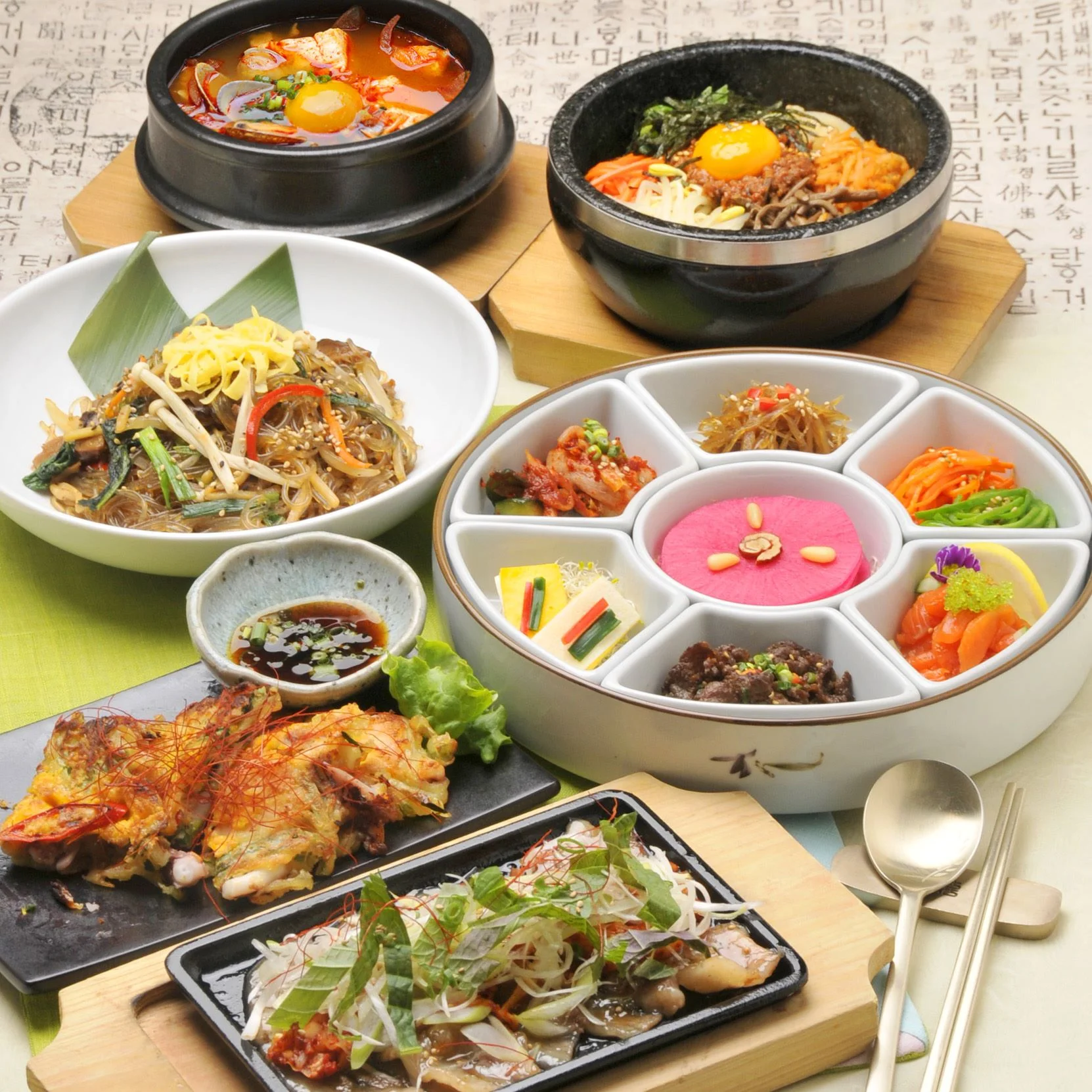 湯気の立つ韓国料理と小皿が並ぶ食卓